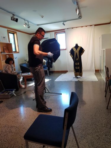 Puawai Cairns and Maarten Holl at the Raglan and Districts Museum capturing images of the dress Eva Rickard wore on the day she was arrested at the Raglan Golf Course, 40 years ago. Photograph by Migoto Eria, Te Papa